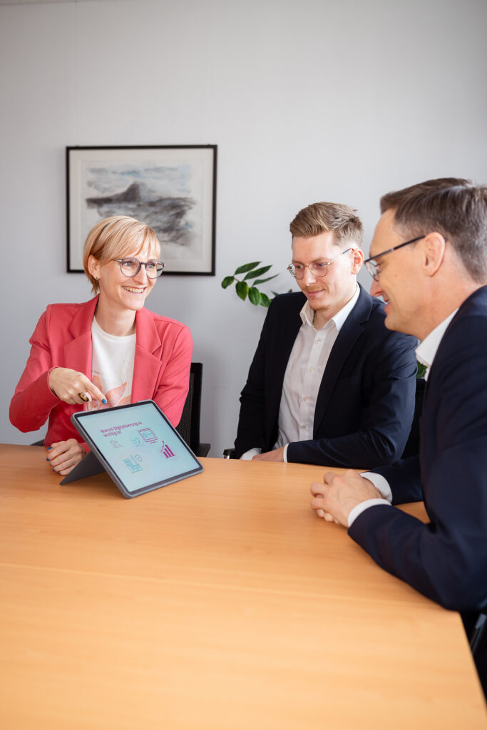 Steuerberater der Wengert AG in Singen besprechen steuerliche Auswertungen gemeinsam am Tablet im Büro der Kanzlei.